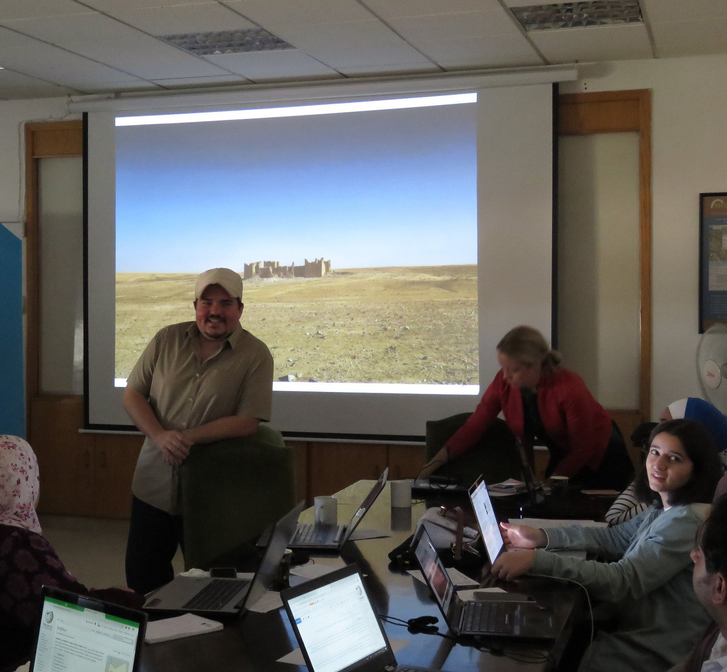 A trainer presenting to adult participants working on laptops during a training workshop in Amman, Jordan